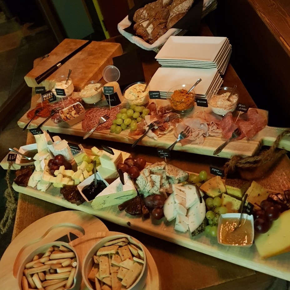 Een borrelplank met kaas, vleeswaren, druiven en brood